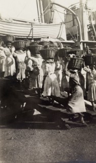 Women refueling a ship, Jamaica. A team of Jamaican women carry baskets of coal aboard a ship, as