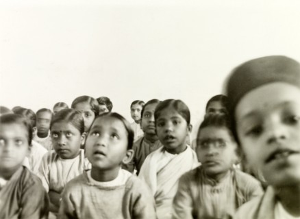 Indian schoolchildren. A class of Indian schoolchildren sit on the floor and listen attentively to