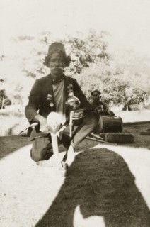 Indian snake charmer. An Indian snake charmer poses for the camera with a coiled up cobra