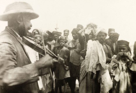 Methodist missionary playing violin. Mr A.C. Arthur, a Methodist evangelist, plays a violin to a