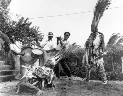Carnival dancers on Nevis. Two men perform a carnival dance outdoors, accompanied by a musical band