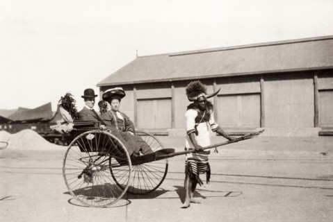 Zulu rickshaw driver, Durban. A Zulu rickshaw driver takes a European couple for a ride. He is