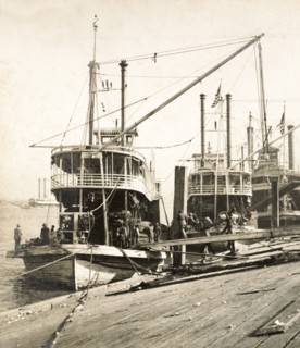 Unloading oil cake, New Orleans. Sacks of oil cake is unloaded from a cargo ship at a wharf on the