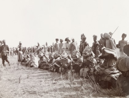 Masked 'devil dancers' at Coronation Durbar, 1903. A group of 'lamas' (Buddhist monks) sit in a row