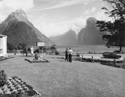 Milford Sound from the Milford Hotel. A couple admire the view of Milford Sound from the lawn of