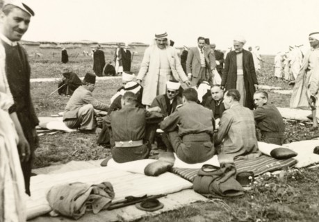 Recruitment meeting at Al Faluja. British colonial and military officers sit on padded mats and