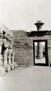 Temple of Ramesses III at Karnak. A line of eroded stone statues guard a courtyard in the Temple of