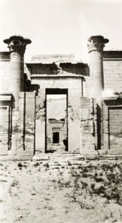 Mortuary Temple of Ramesses III. Two stone pillars stand either side of a gateway decorated with