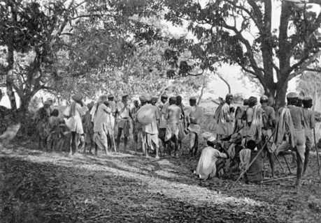 Pig-sticking near Delhi, 1934. A large group of Indian hunters gathers in a forest clearing on a