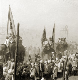 Procession at the Ardh Kumbh Mela. A procession containing elephants and banners passes through