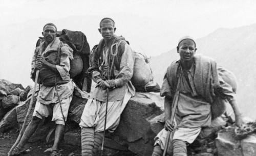 Kashmiri travellers at rest. Three of George Boon's Kashmiri porters rest their heavy loads against