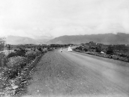 The road to Jamrud Fort. A convoy of camels is led along a road towards Jamrud Fort, a mud fort