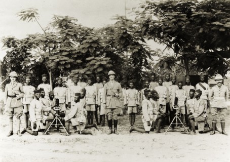 Artillery company of the Nigeria Regiment. Three British officers pose with an artillery company of