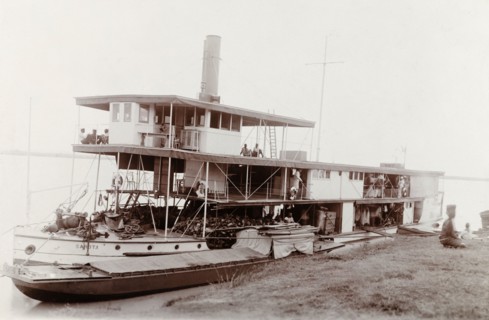 A paddle steamer named 'Sarota', Nigeria. A paddle steamer named 'Sarota' is moored to a riverbank