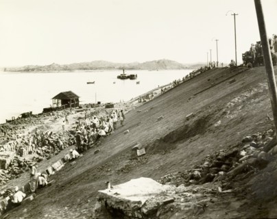 Constructing an embankment at Chauk. Labourers lay pitching bricks on a steep, clay-faced