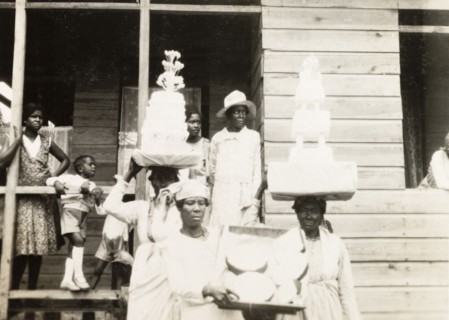 Wedding cakes in Trinidad. Two Trinidadian women balance tiered wedding cakes on their heads as
