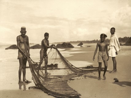 Fishermen on Azhikkal beach. Fishermen prepare their nets on a wide sandy beach. Azhikkal, Kerala,