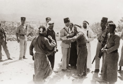 Police questioning Palestinian Arabs, 1938. Armed officers of the Palestine Police Force question a