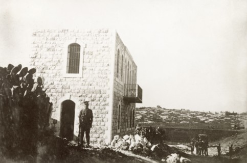 A condemned house in Nablus. A British Army officer stands on guard outside a house on the