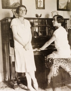 At the piano, Eastbourne. Portrait of two women at the piano in the drawing room of an English