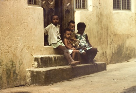 Children in Mombasa. Four children sit on stone steps outside a doorway in Mombasa. Mombasa, Kenya,