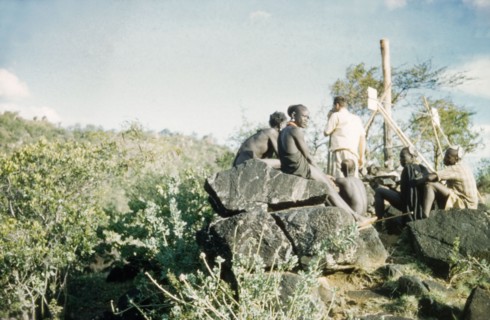 Henry Osmaston takes a bearing'. Accompanied by Suk porters, Henry Osmaston (Working Plans Officer