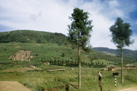 A village in the Belgian Congo. A British District Officer stands on the road beside a village in