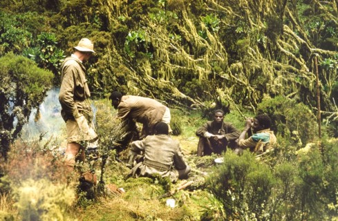 Breakfast in the Rwenzori Mountains. African porters with a British forestry survey team sit around