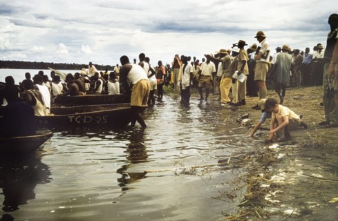 Regatta at Katunguru. Crowds line the banks of the Kazinga Channel to watch a canoe race at the