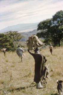 A female porter descends Mount Napak. A female porter carries equipment belonging to a British