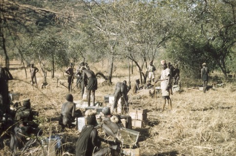 Porters on safari to Mount Napak. Supervised by an askari (soldier), a group of porters ready their