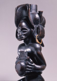 Chief holding a sanza, a musical instrument of the ideophone family, with metal keys and gourd resonator