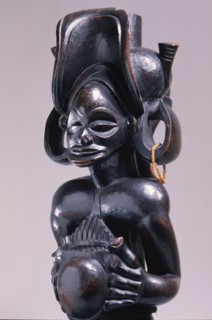 Chief holding a sanza, a musical instrument of the ideophone family, with metal keys and gourd resonator