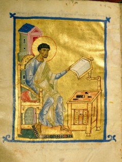 An illumination from a manuscript depicting St Luke at his desk on which there appears to be a set of engravers tools