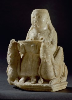 Hollowed out figure of a female goddess of oriental origin, possibly associated with Astarte, seated on a throne like chair, flanked by two winged sphinxes