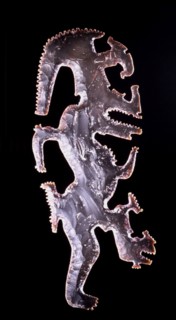Eccentric axe with representation of the God K, the god of lightning, recognised by the torch running through his forehead and an elongageted serpentine leg