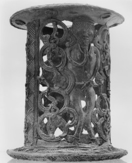 A bronze stand that incorporates the images of a warrior