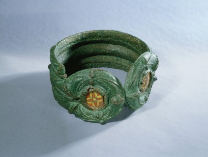 Heavy bronze bracelet decorated with enamelled discs and coloured glass