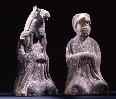 Two male kneeling figures representing animals of the zodiac