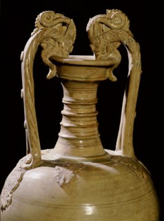 The upper section of a glazed pottery amphora with dragon headed handles