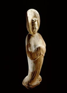 A painted earthenware figure of a lady wearing a voluminous hooded cloak