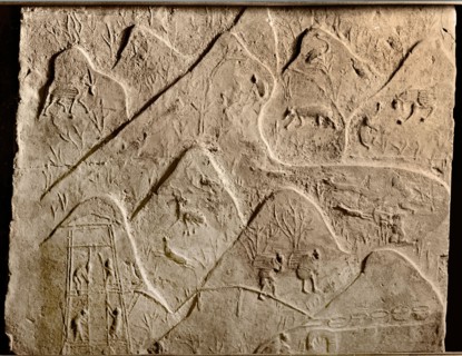 Brick from a tomb structure impressed with design of hills with a hunting scene and peasants gathering wood