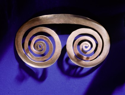 Gold spiral breast ornament thought to be a schematic representation of an owls face