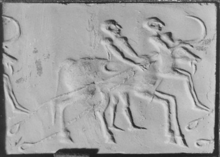 A man walks beside an ox which drags its traces along the ground