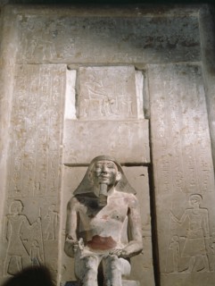 The tomb owner seated before the false door to his tomb