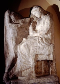 A seated young woman taking an ornament from a box presented by a servant