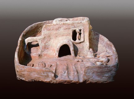 A model of a house with a rounded door and a staircase to the roof which has a vent to catch the cool breeze
