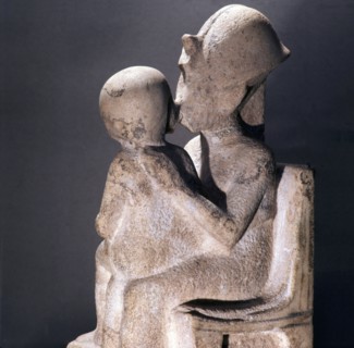 Akhenaton kisses his daughter as she sits on his lap