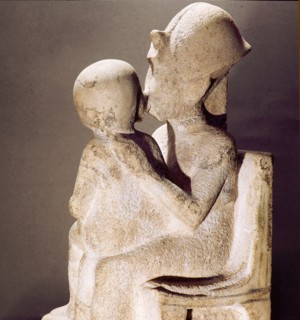 Akhenaton kisses his daughter as she sits on his lap