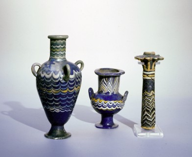 Core glass cosmetic vessels decorated by impressing heated glass rods of various colours to the body of the pre heated vessel